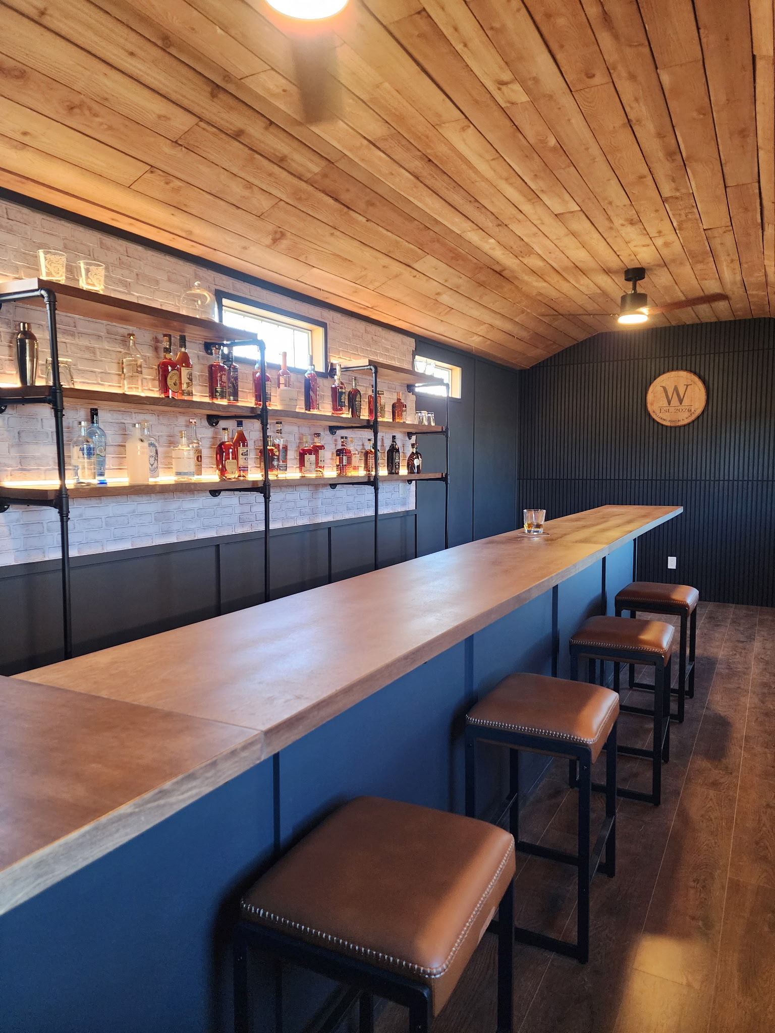 Finished bar room with wood ceiling, lighting, and outlets